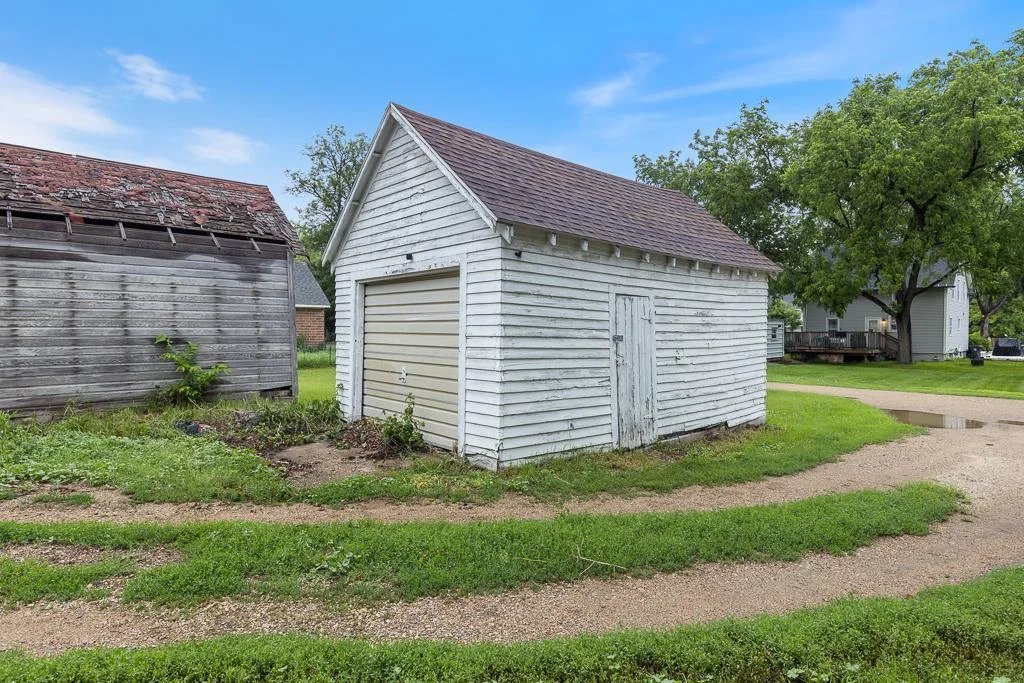 This detached garage features 2-year-old shingles for added protection. While the siding could use a refresh, it offers great potential for extra storage or workspace.