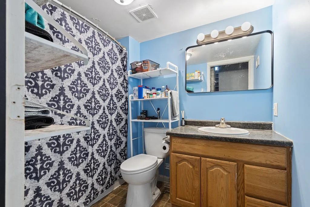 The main floor full bathroom features a 2023 updated toilet and shower head, combining modern style with added comfort and efficiency.