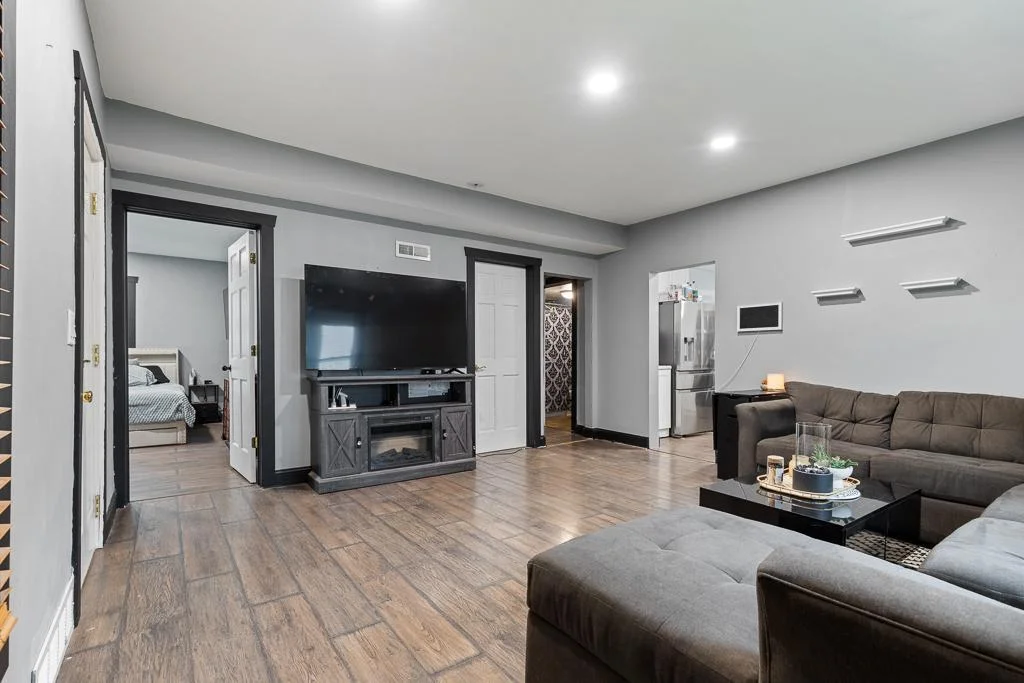 The primary bedroom and kitchen are conveniently located just off the living room, creating a smooth flow and easy access between key living spaces.