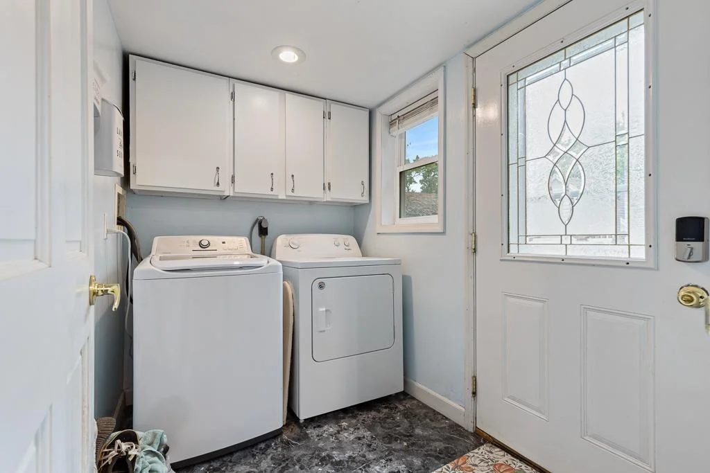 The laundry room, located just off the kitchen, features new flooring and a 2022 washer—making household chores easier and more efficient.