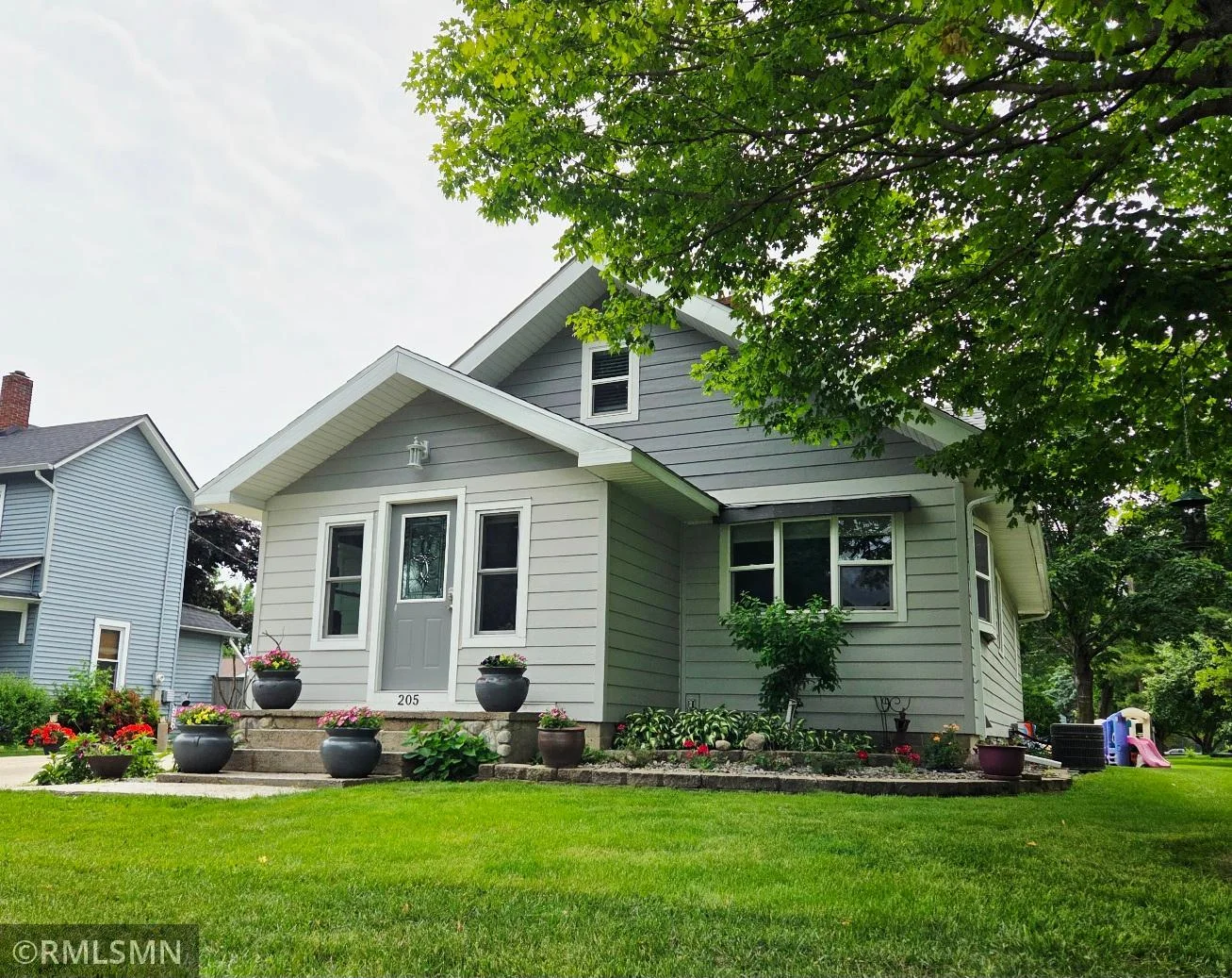 Cute curb appeal with blooming charm all around.
