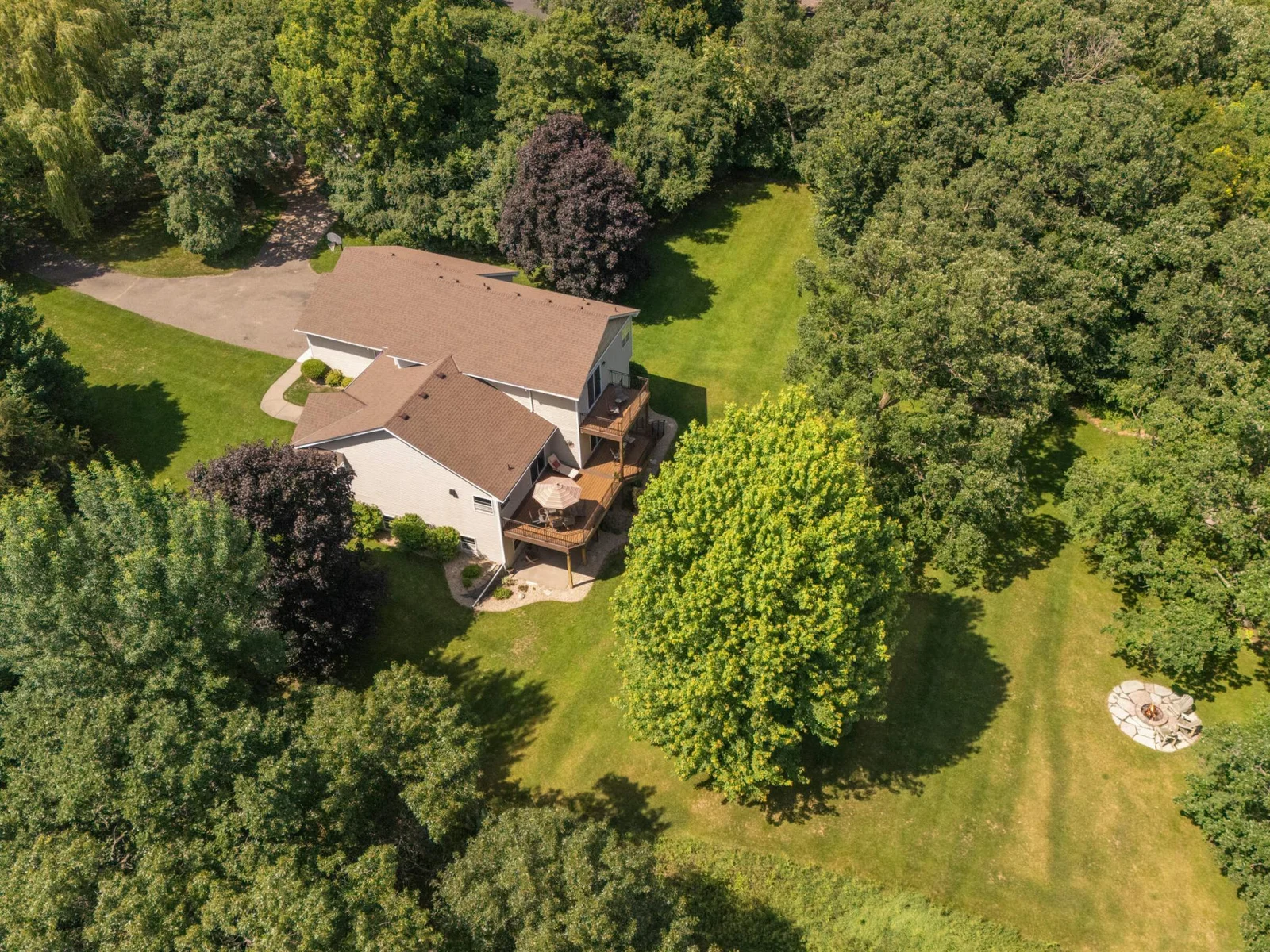 Medium tree coverage surrounds the home, creating a peaceful, secluded retreat while still allowing sunlight and scenic lake views.”