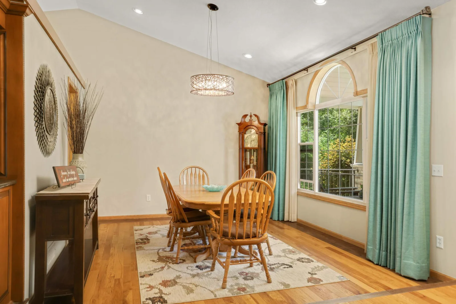 A large front-facing window fills the space with natural light, highlighting the stunning inlaid hickory hardwood floors