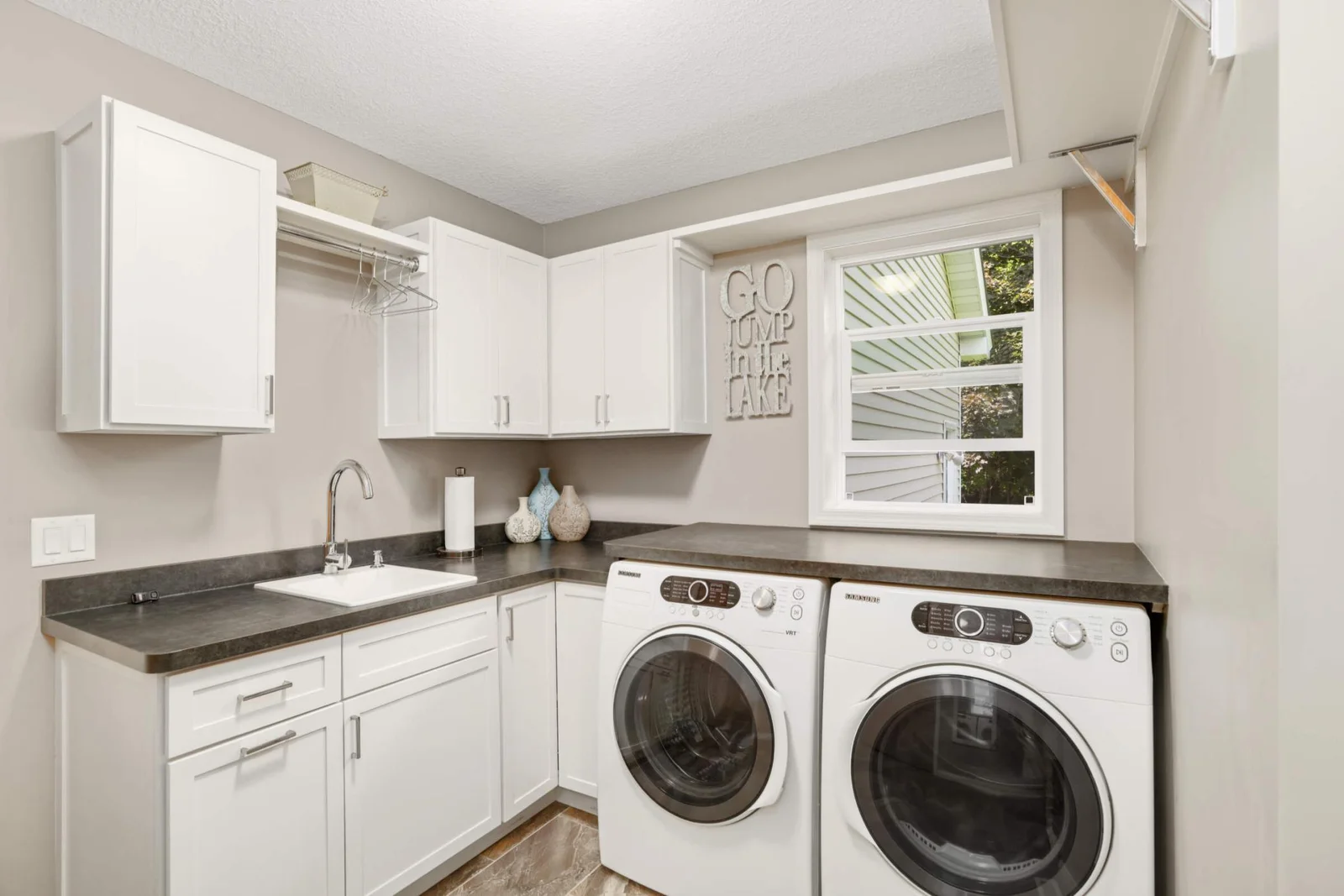 Convenient main-level laundry features ample cabinetry for storage and a front-loading washer and dryer for easy access.
