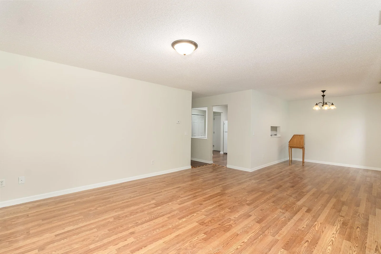 View of living rom and peek at kitchen and dining area with pass through