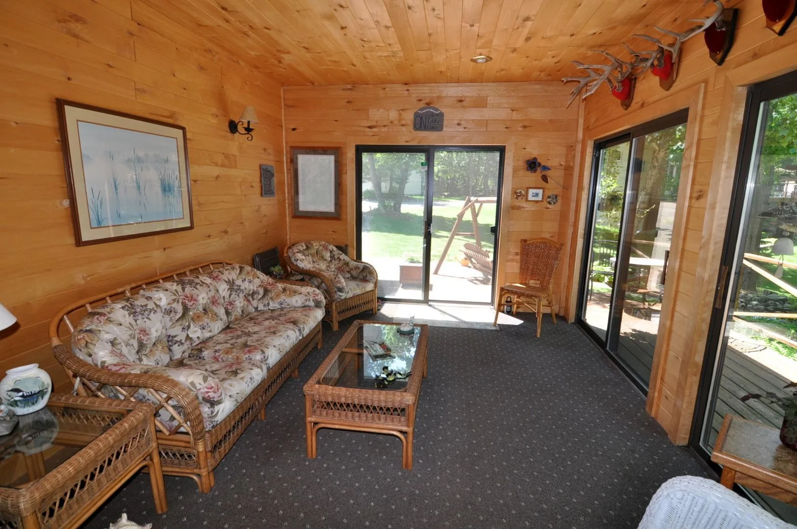 Cozy sunroom wrapped in pine with vaulted ceiling and beautiful views of the property.