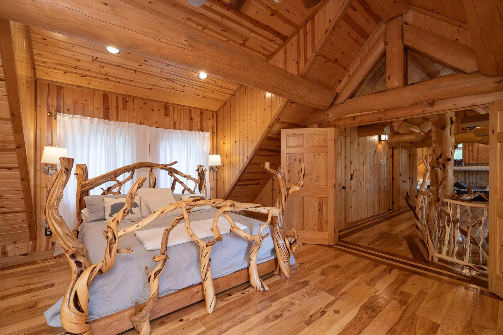 Upper level bedroom with vaulted ceilings, French doors, and custom made bed