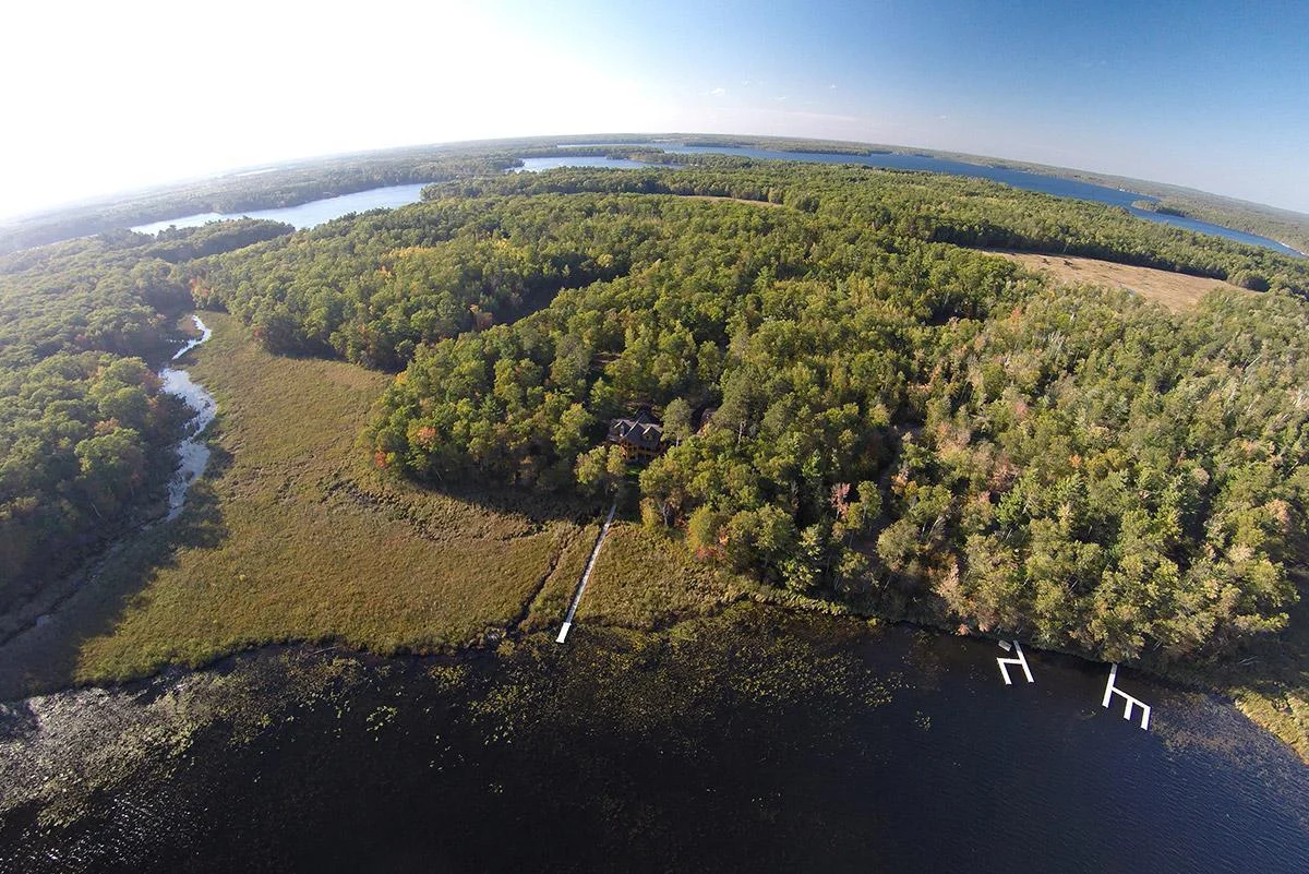 Aerial drone photo from above the lake looking towards the home and the 40 acres
