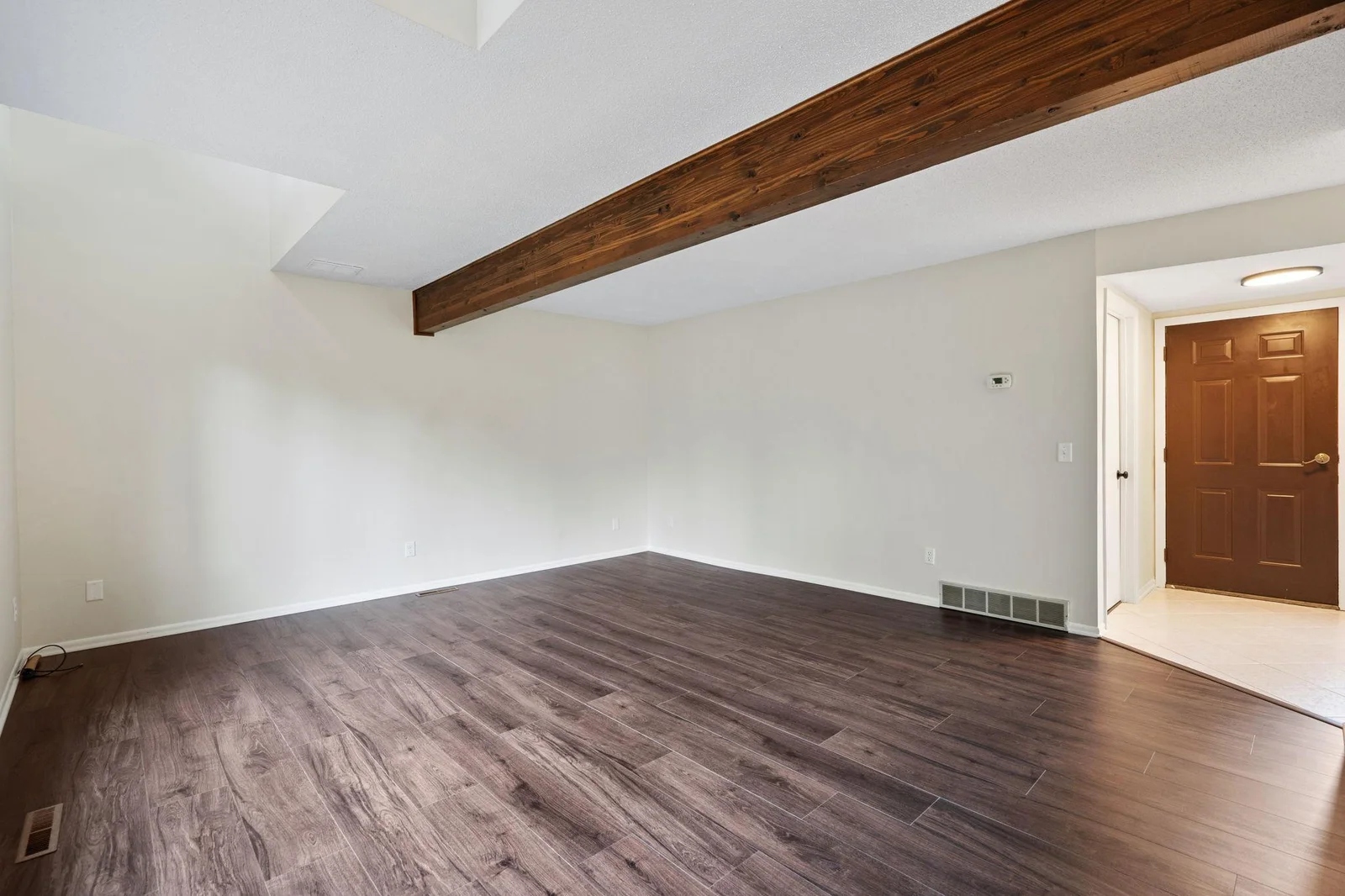 The beamed ceilings and vaults to the upper level make this living room bright and airy.