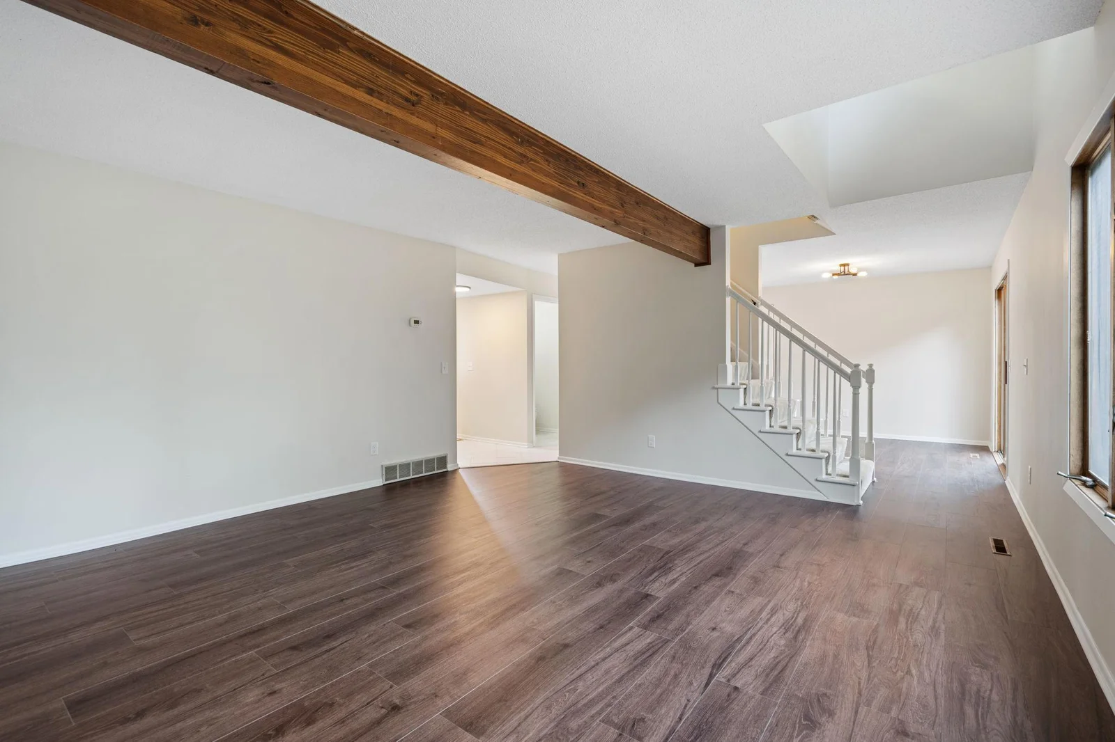 The central staircase divides the large living room from the dining room.  Both sprawling rooms are filled with light from the west facing windows.