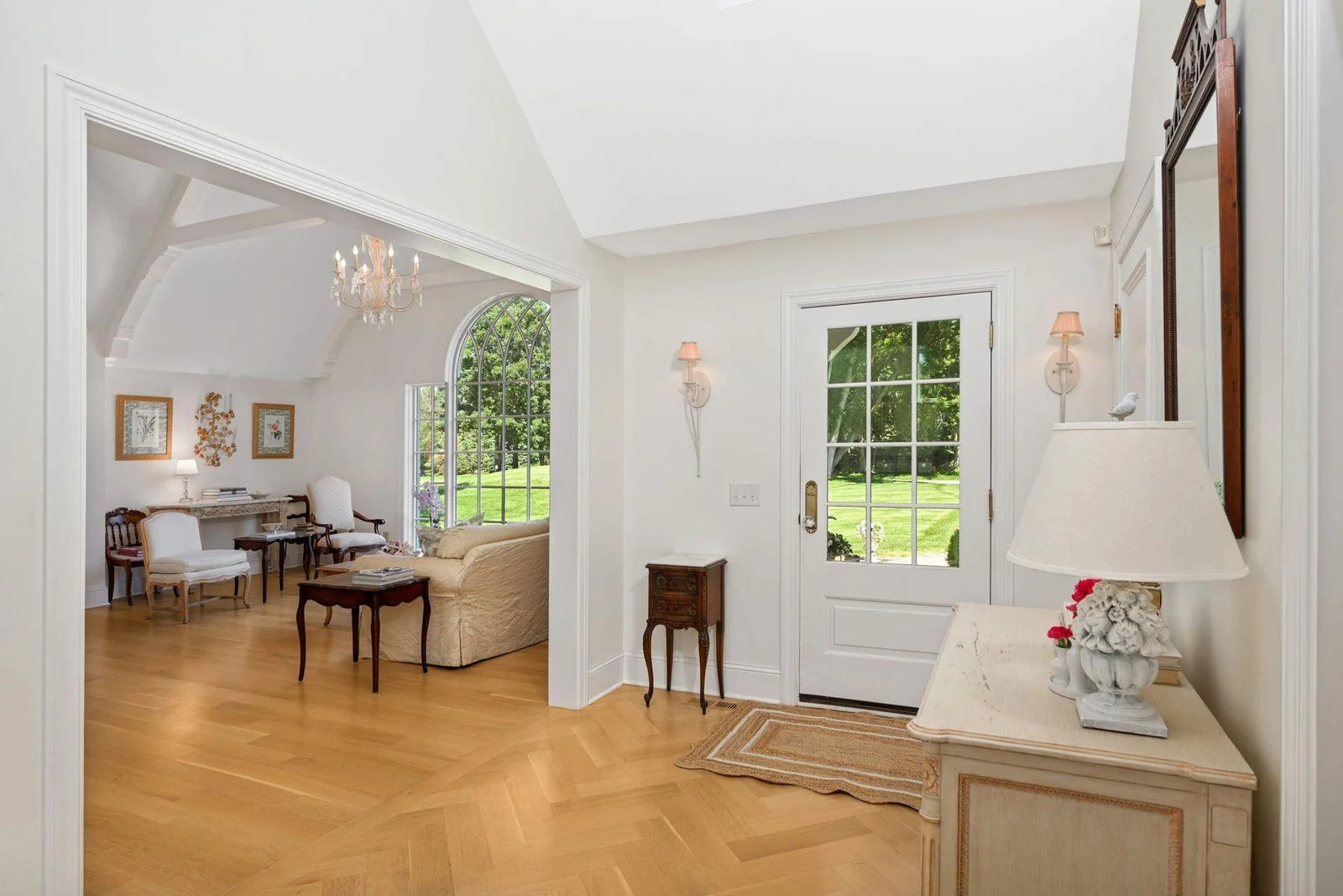 The foyer features white oak inlaid in a herringbone pattern, pretty sconces and a coat closet for ease.
