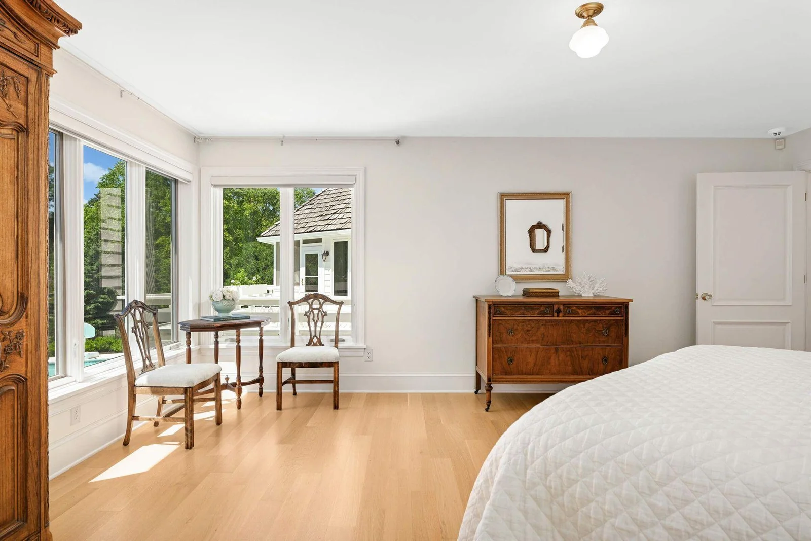 The primary bedroom overlooks the backyard, and the deck and pool area off in the distance.
