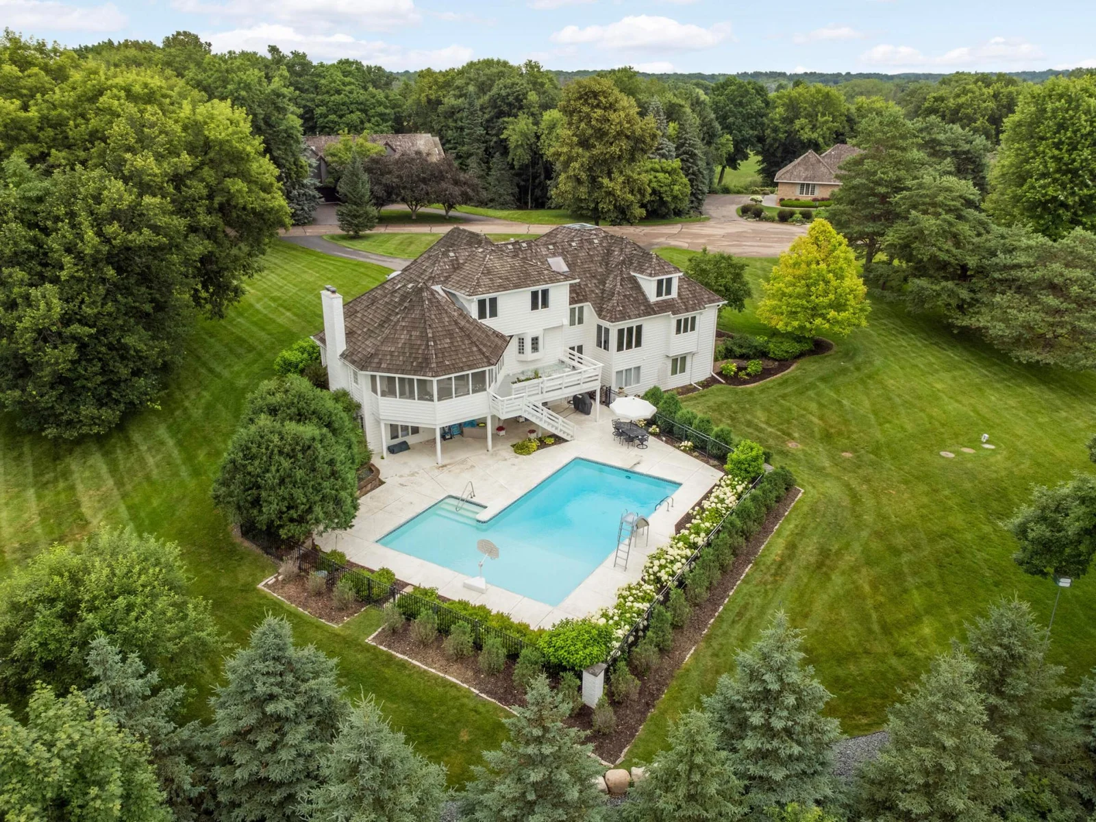 Set on a picturesque lot with pretty views, perennials and shrubs gracing the pool.
