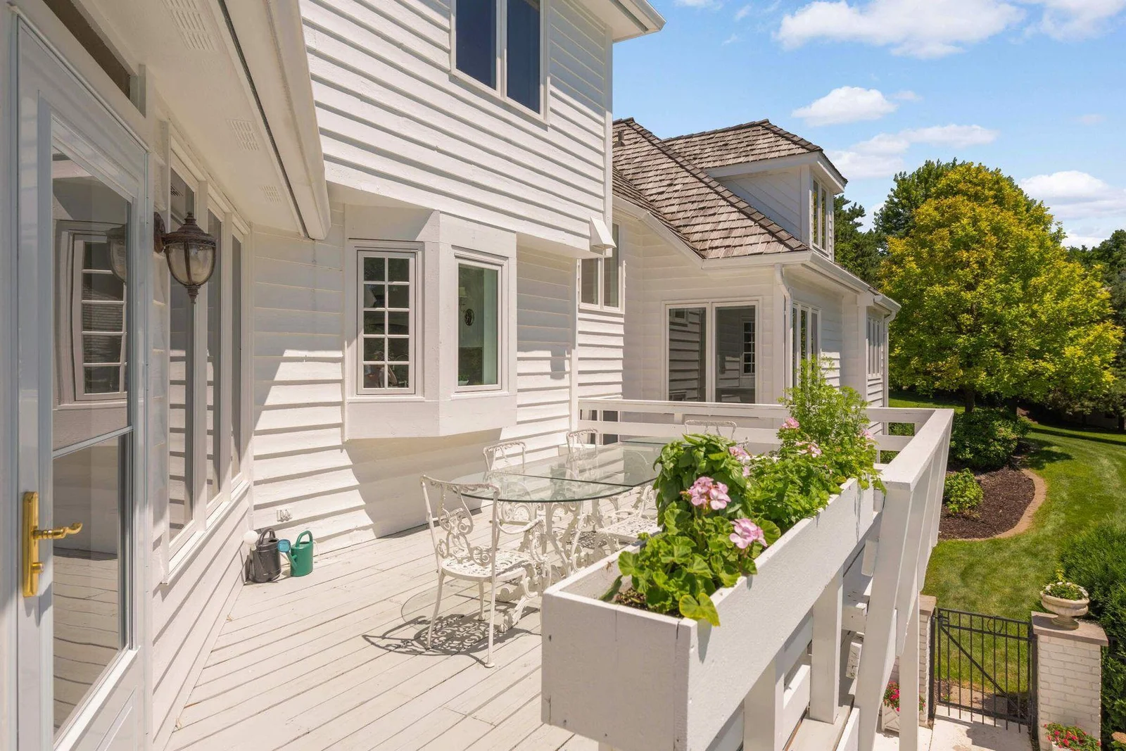 The deck is one of two outdoor eating areas, overlooking the grounds and some of the pool.