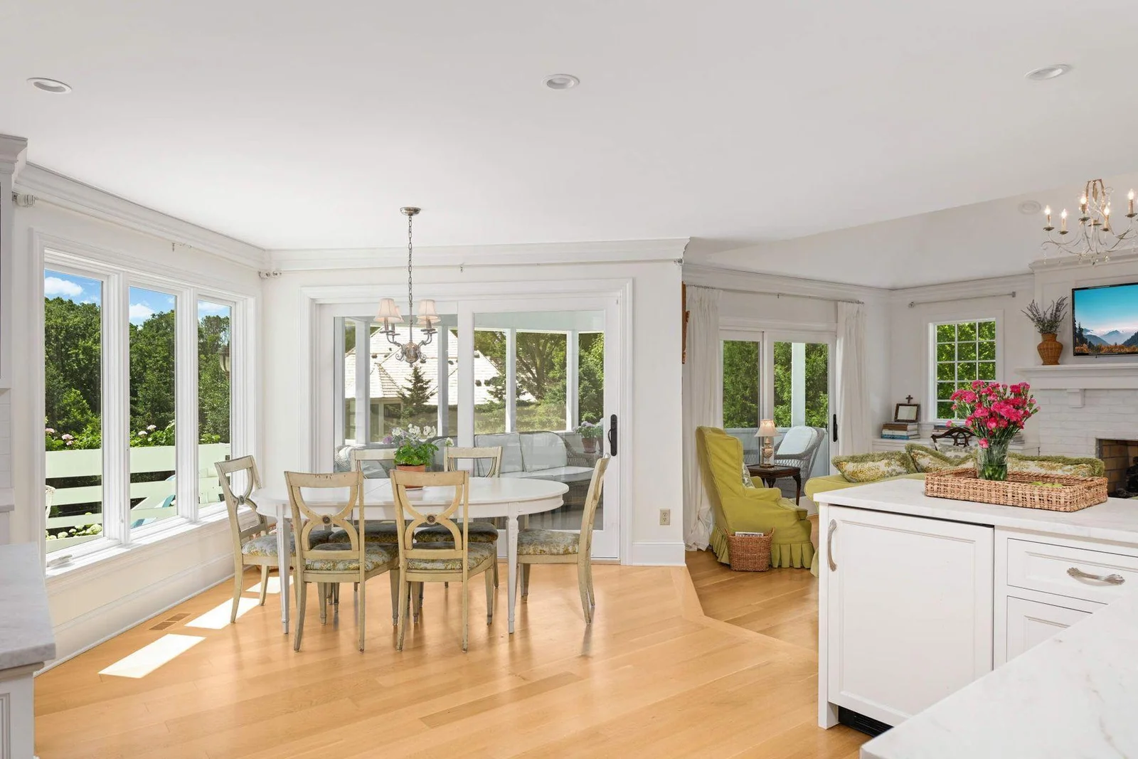 White oak runs throughout the living/entertaining spaces, and here the three season porch is off the informal dining area, which also steps down into the family room.