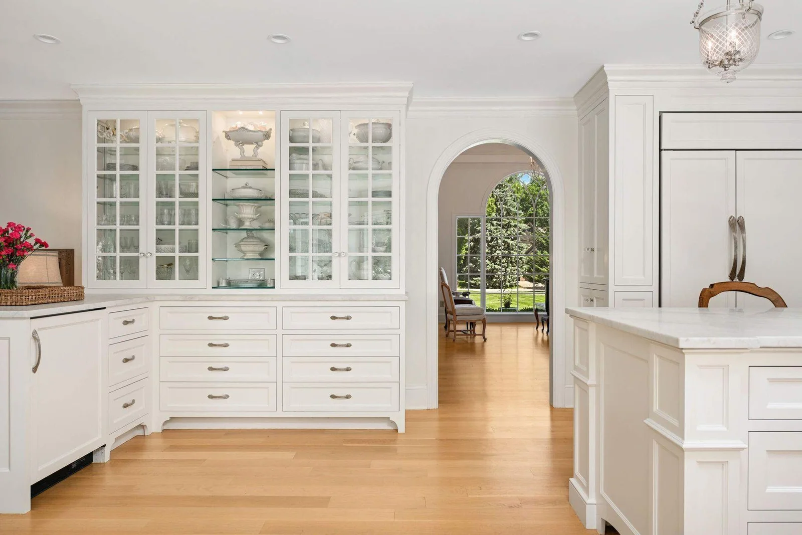 Arched design thoughtfully corresponds with one another. There is a beverage cooler just to the left of the lower cabinet doors.
