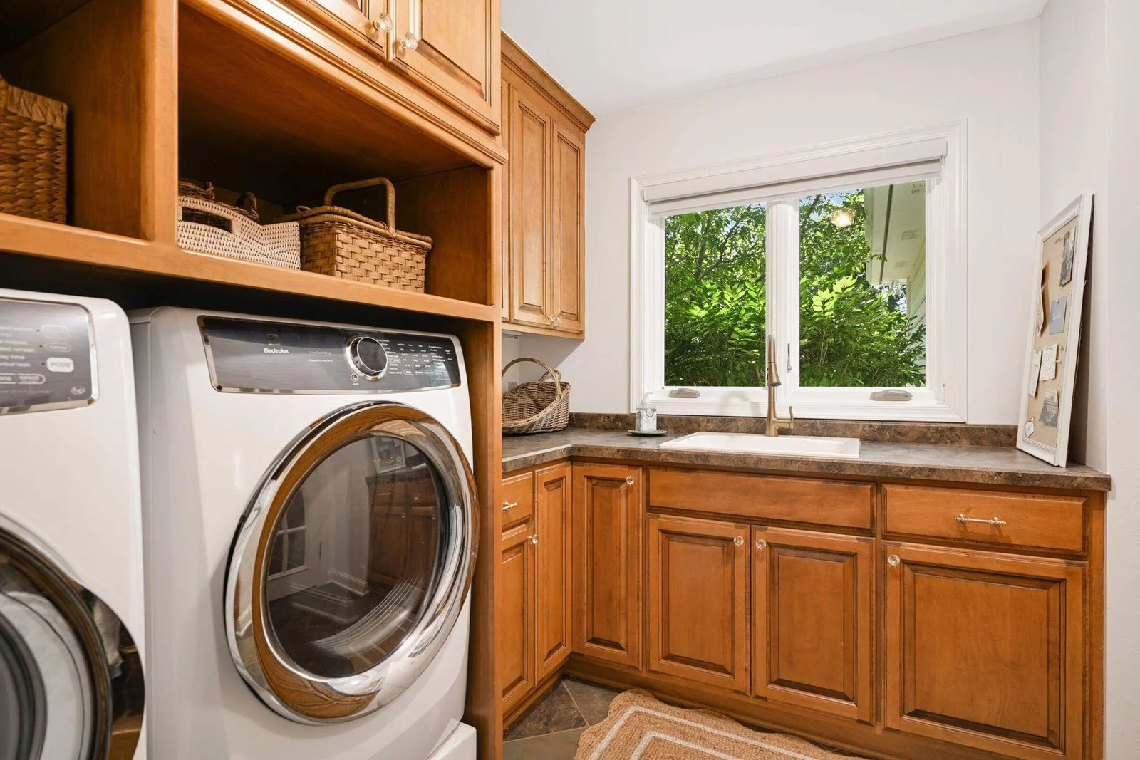 Just off the mudroom is the laundry room, but with lots of extra cabinets, a sink and window overlooking the backyard -- the perfect butler's pantry or flower room, too!