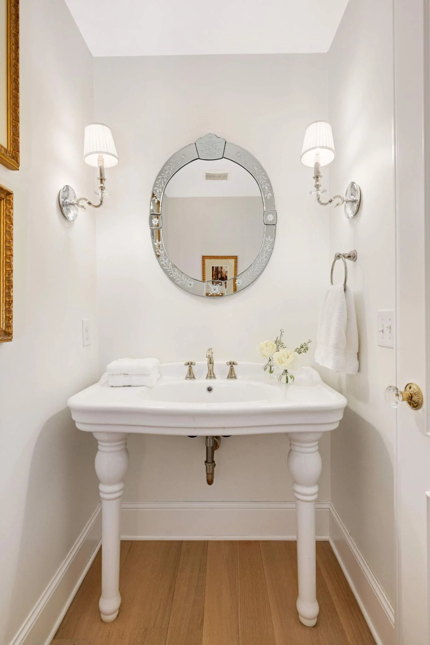 The powder bathroom is studded with beautiful things: the oversized pedestal sink is a wow factor.