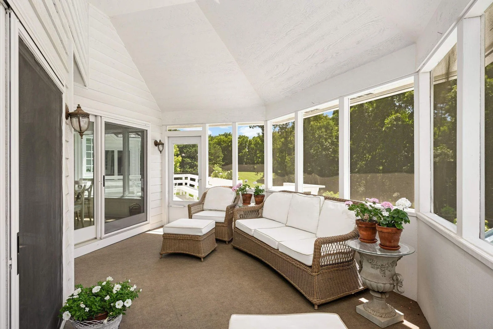 The three season porch has access to the deck, and overlooks the pool area and wooded acreage.