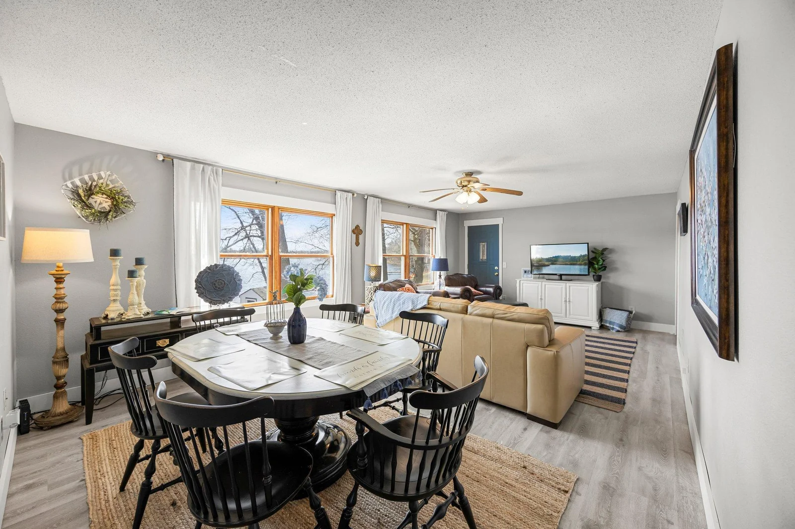 Open concept dining room/living room with large windows overlooking Big Pine Lake.