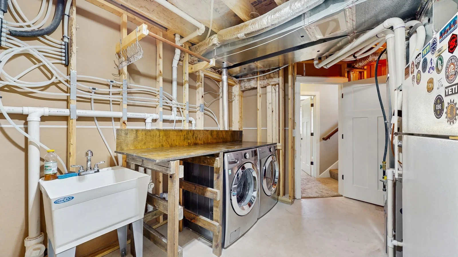 Front load washer/dryer with a custom built countertop and laundry basket holder.