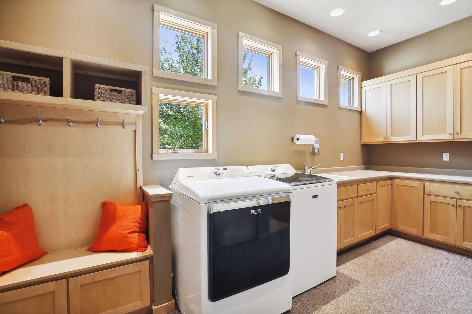Custom built means fabulous, storage spaces and nooks! Check out this beautiful main floor mud room with laundry. Awesome window design brings natural light in. Abundance of custom cabinetry and storage!! Bench and hooks for all the extras!