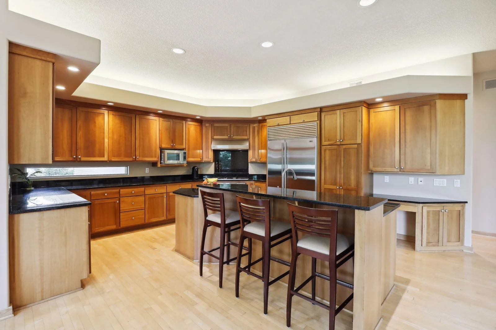 Gorgeous custom kitchen with ample counter space. Unique under cabinet windows are a standout!