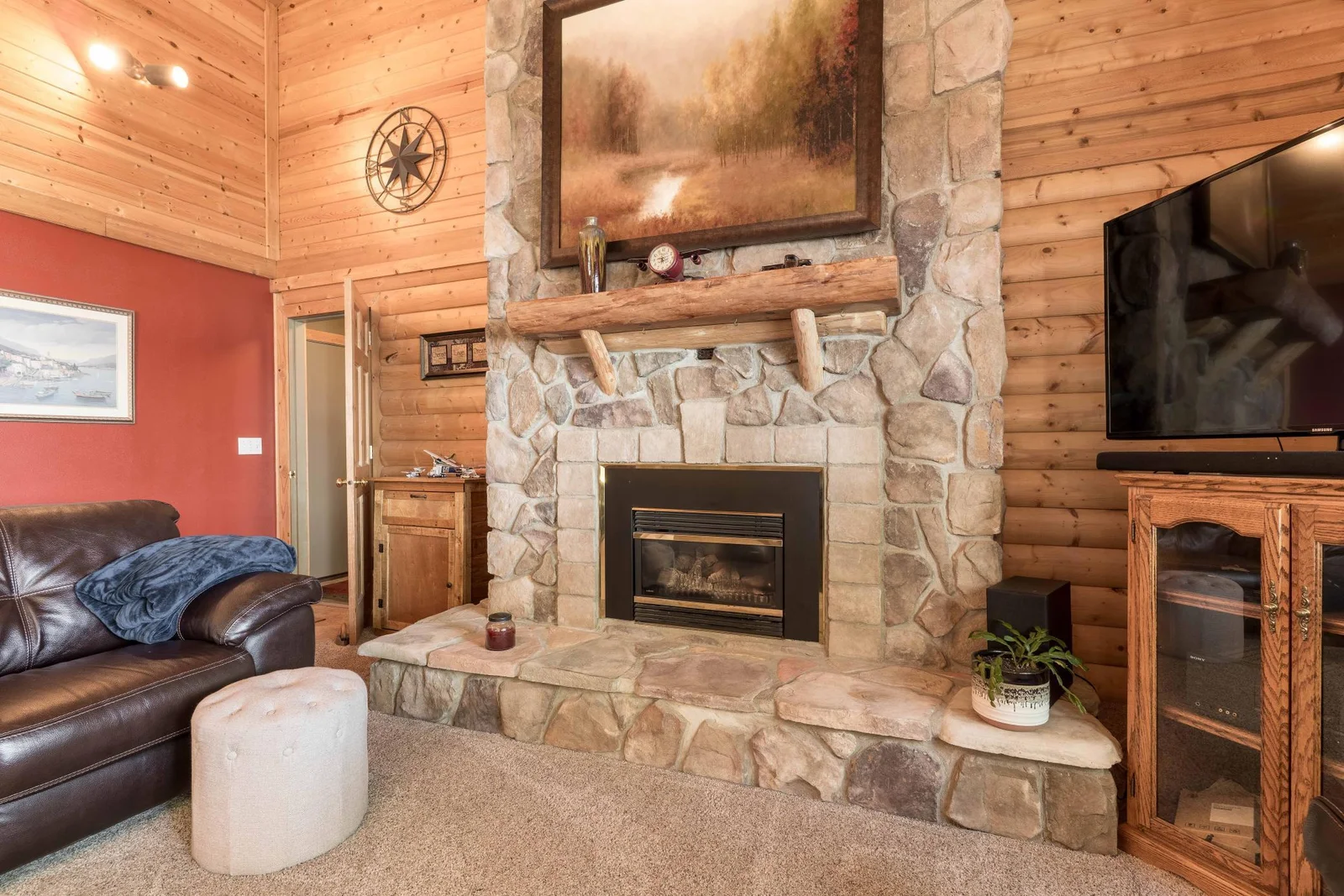 large stone fireplace floor to ceiling. with log Mantel.
