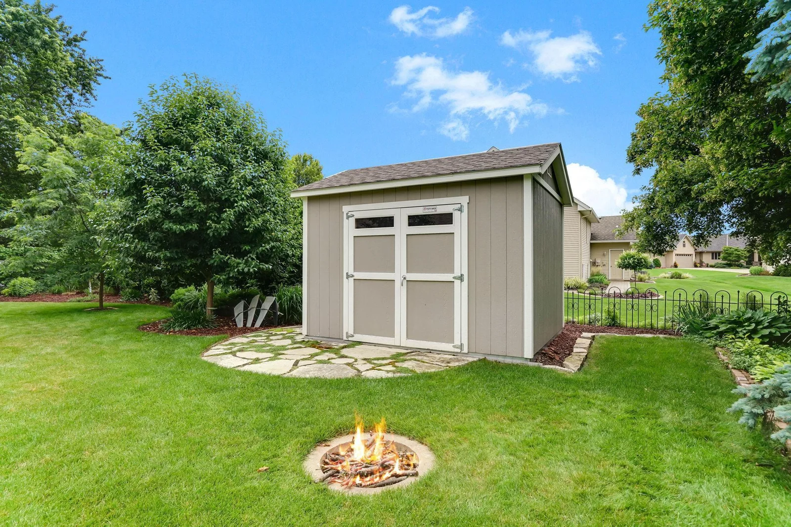 Storage shed, fire pit and a bit of fencing in the back yard.