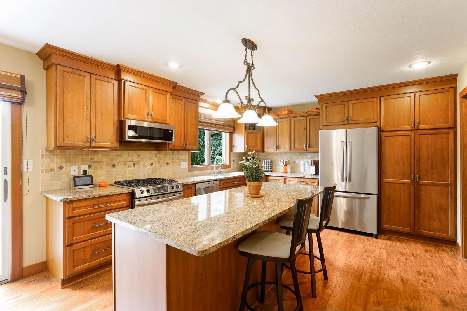 Maple cabinets with a a cherry stain finish, crown molding, stainless steel appliances and granite tops.