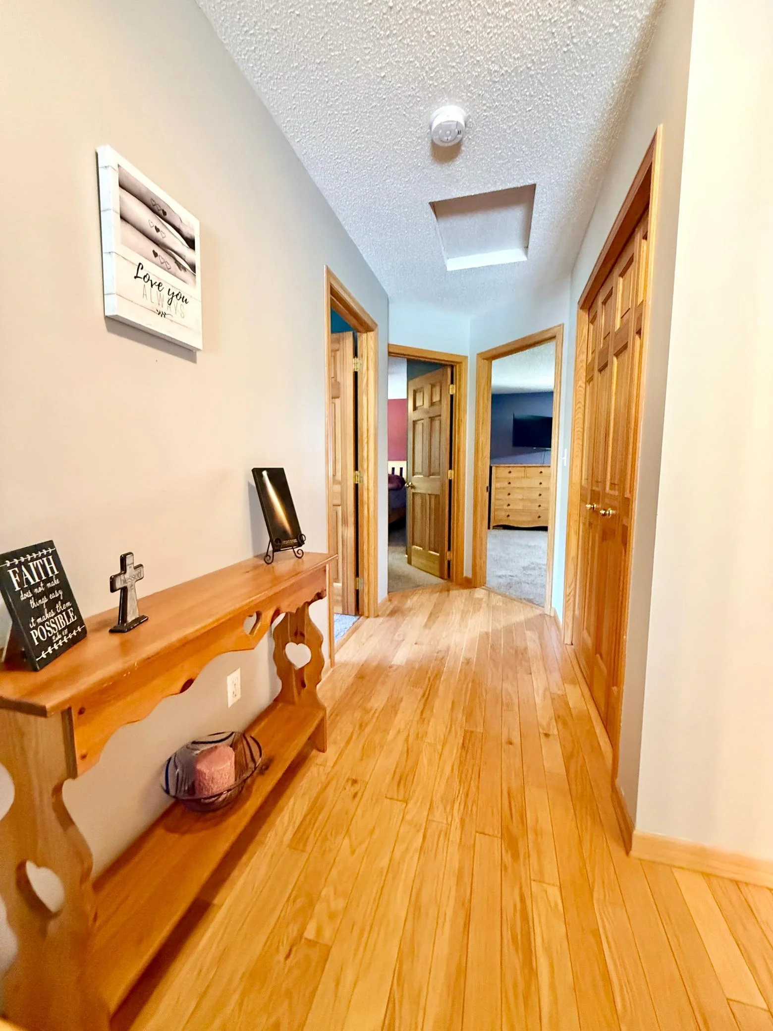 Wide hallway leads to the 3 bedrooms. Primary bedroom is located through the open door on the right.