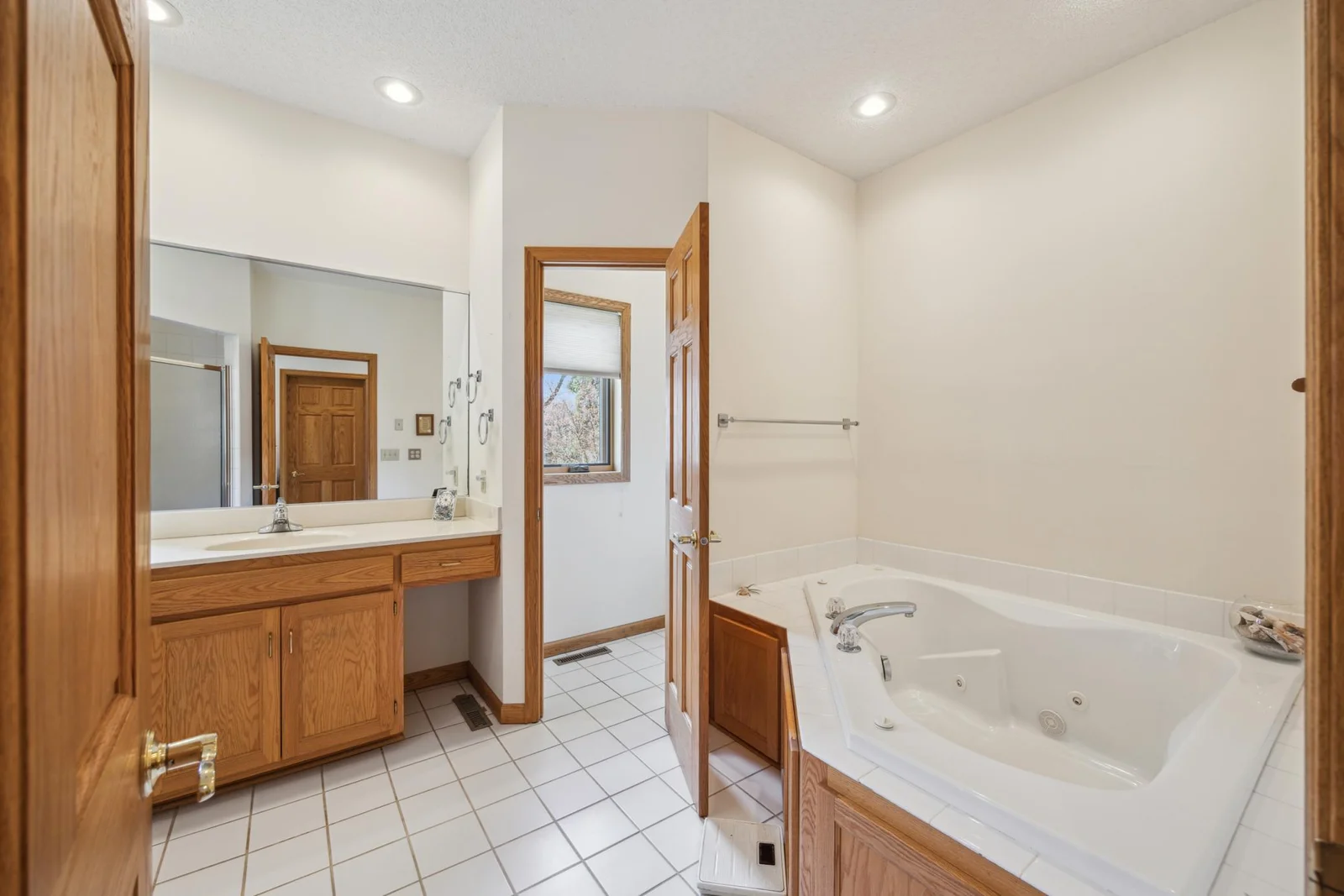 Primary bathroom with jacuzzi tub and separate shower with 2 sinks.