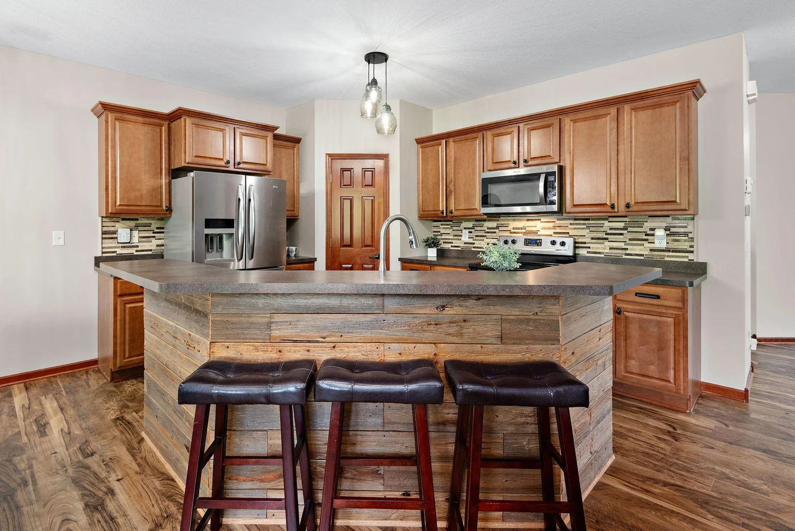 Huge Beautiful Kitchen that has a center island with barnwood accent, tile backsplash, High Breakfast Bar, walk-in pantry, stainless steel appliances - kitchen in open to Living Room, Dining Room and SunRoom Addition!