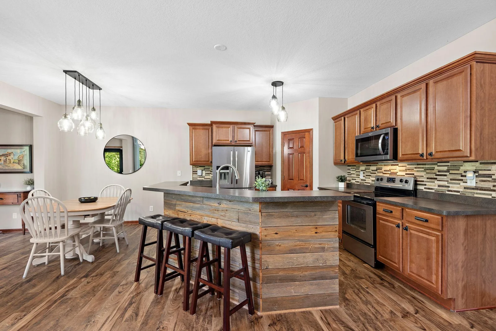 Center island with barnwood accent, tile backsplash, High Breakfast Bar, walk-in pantry and stainless steel appliances!