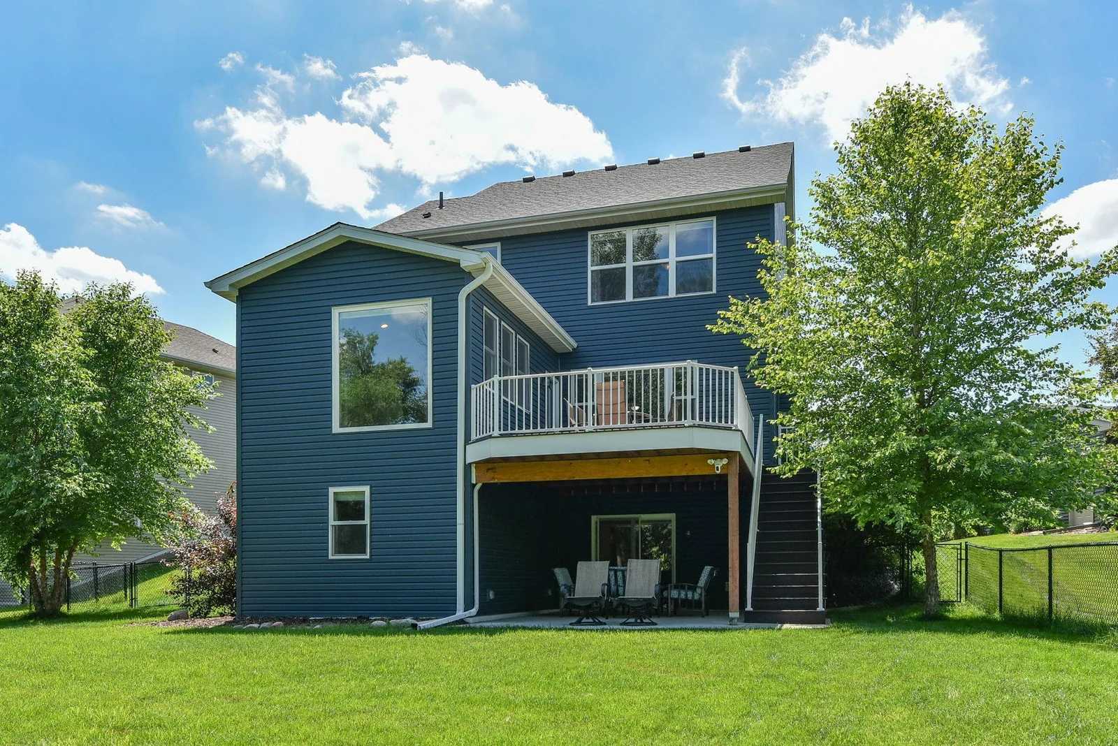 Rear view of home showing maintenance free deck with steps to back yard and covered patio!