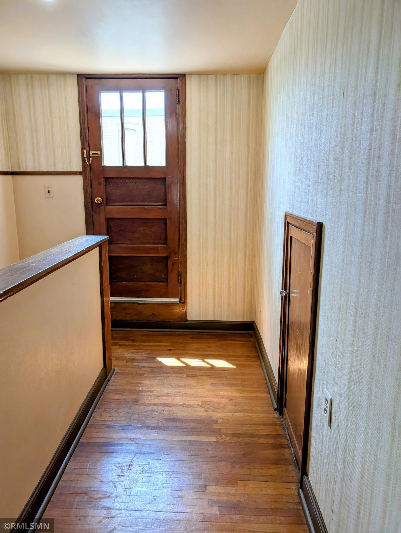 Upstairs hallway. Kneel wall storage. Door leading out to the balcony