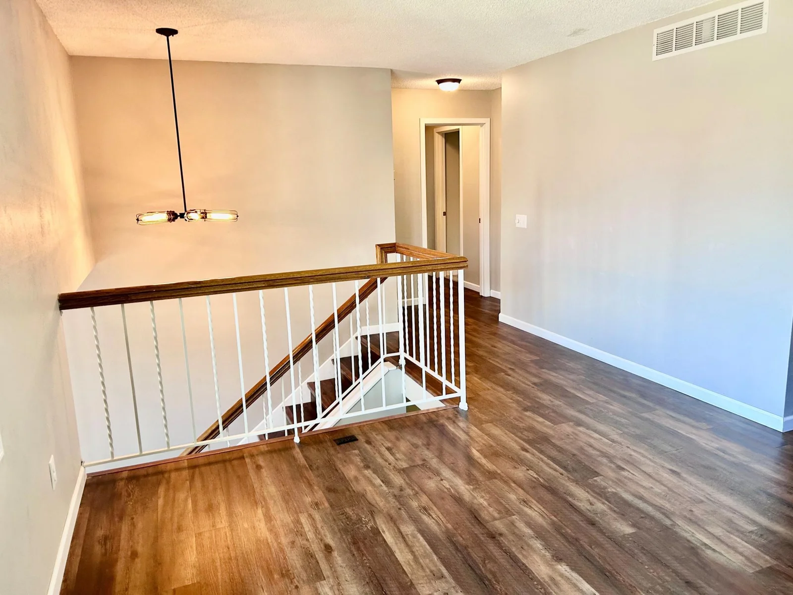 Living room view of stairs and hallway to bedrooms and bath