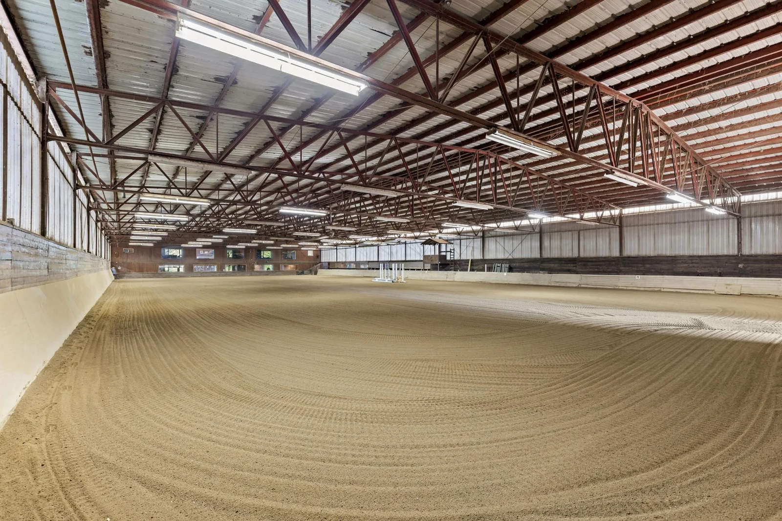 100' x 200' heated Indoor Arena - Steel Construction - 6' observation aisle on north side of indoor - Footing: fine to medium sand with sub-angular particles over an aglime base