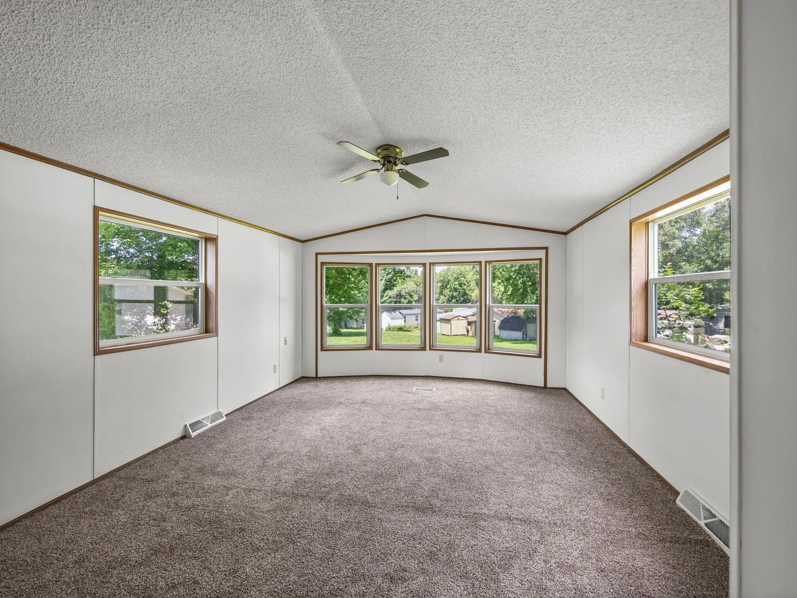 The living room features vaulted ceilings and new carpet.
