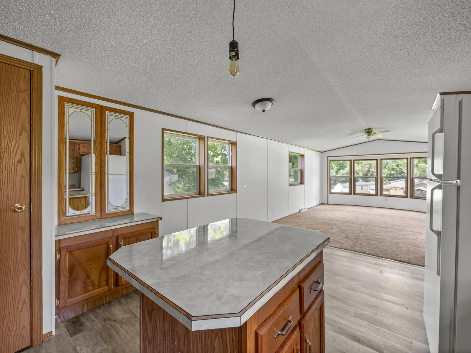 The kitchen features a center island and a pantry cabinet.
