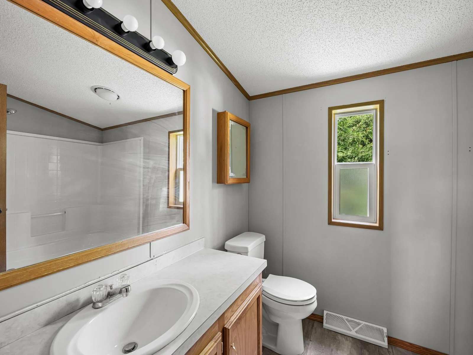 The bathroom features LVT flooring and an oak vanity.