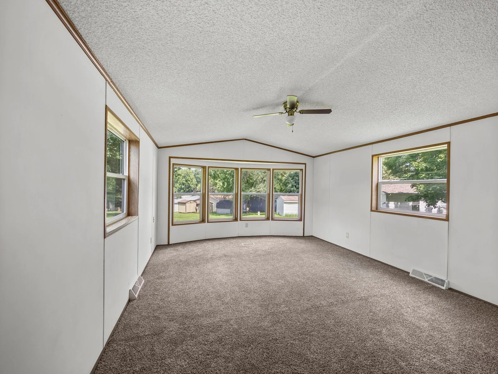The living room features vaulted ceilings and new carpet.