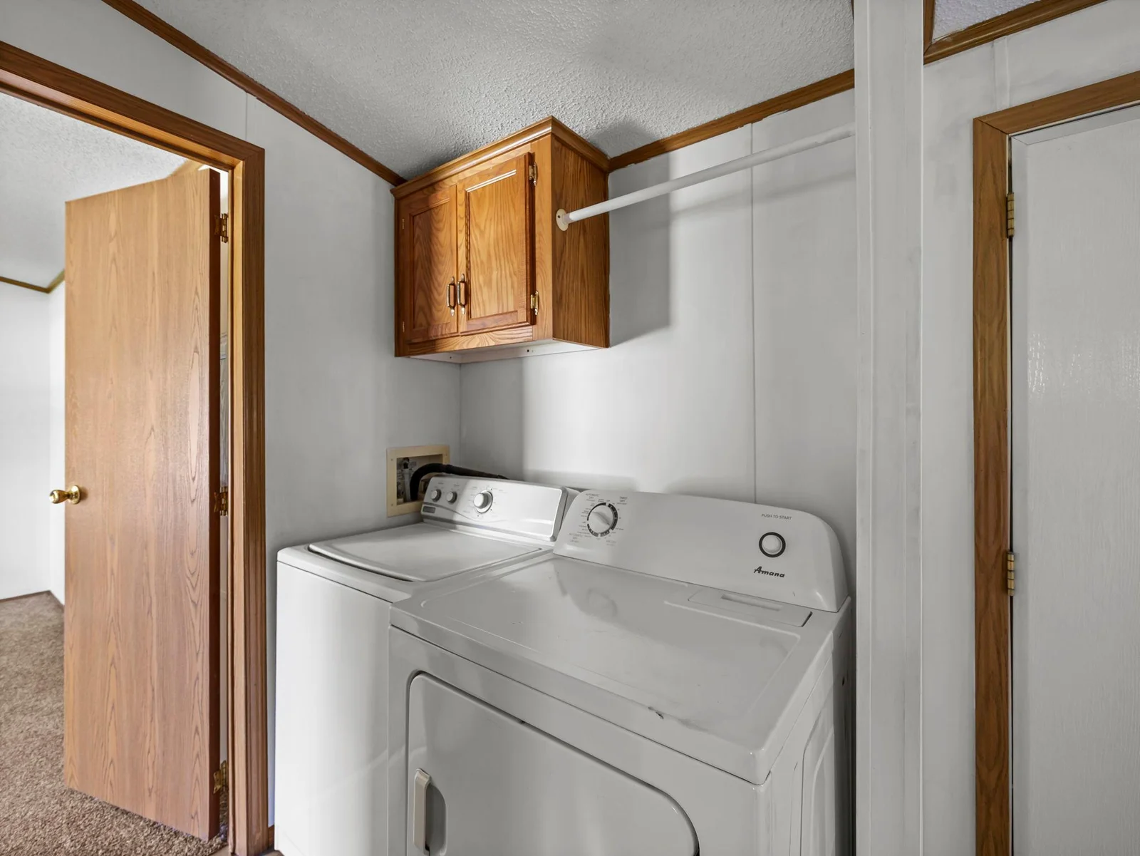 The hallway laundry room features LVT flooring and some additional storage.