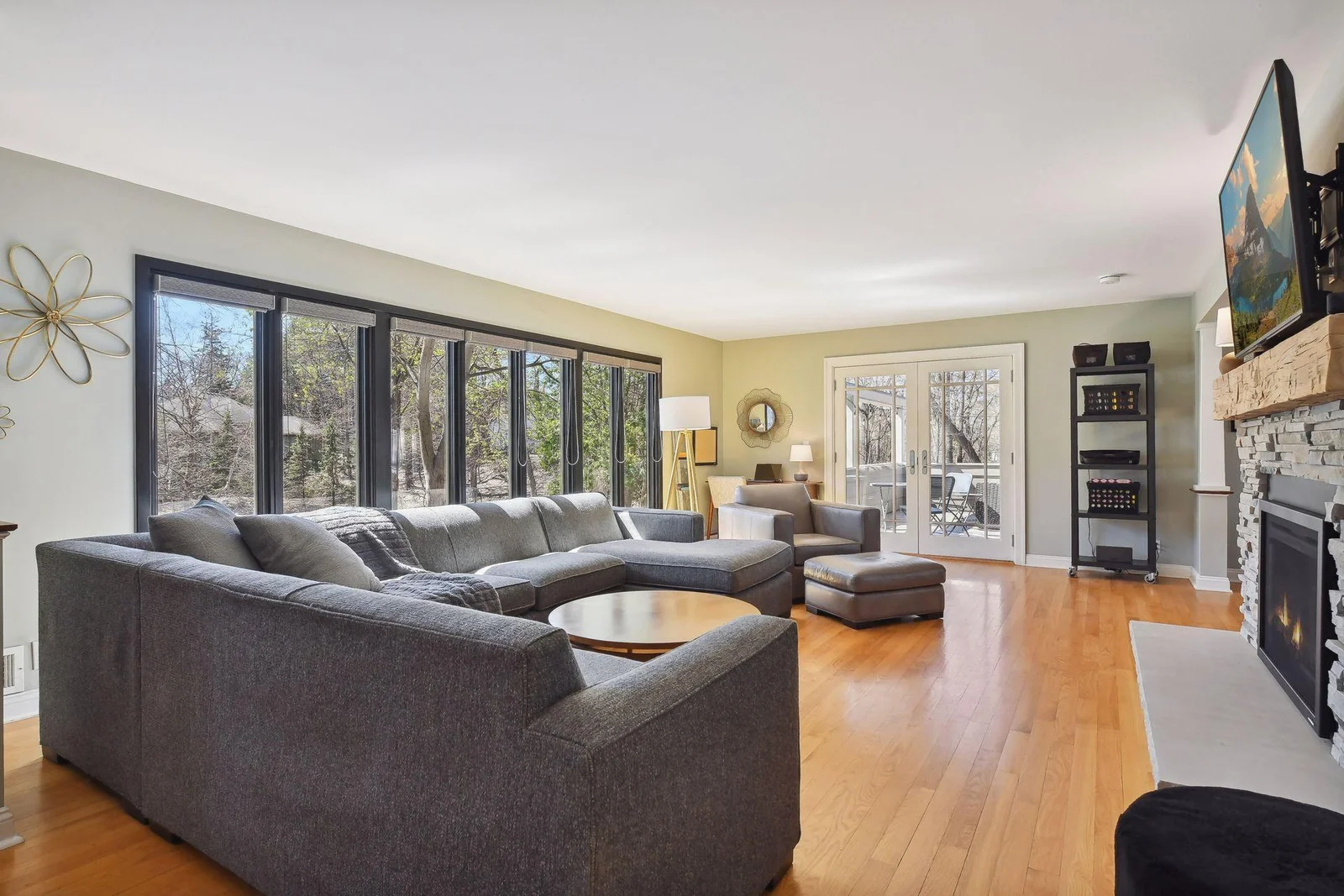 The home's living room is filled with natural light thanks to the expansive wall of windows (all new Marvin windows throughout in 2018)