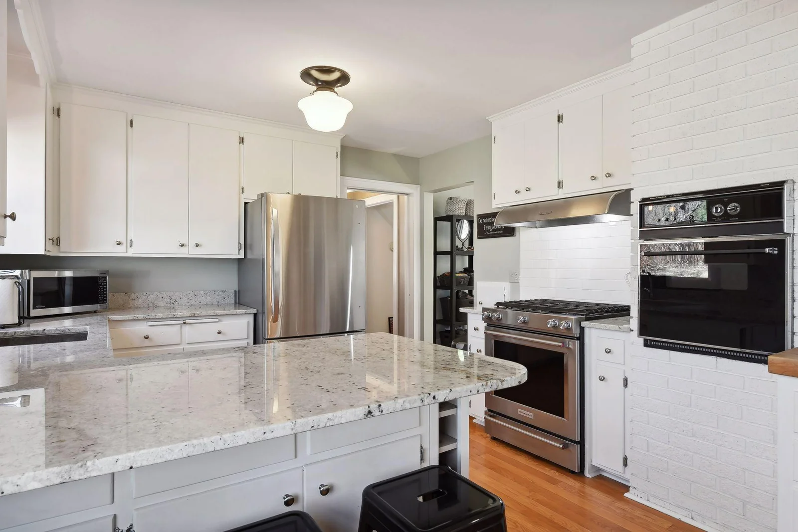 Bright white kitchen with SS appliances, granite countertops