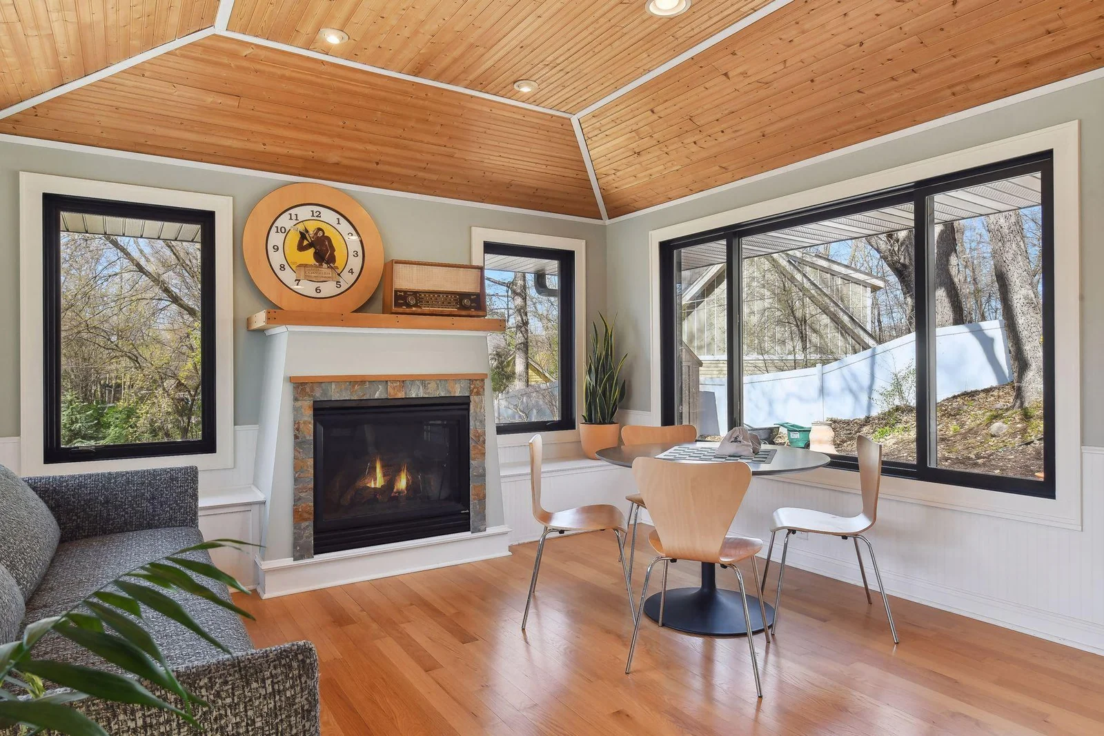 Cozy gas fireplace, hardwood floors, tray ceiling with wood accents, and plenty of windows to let the natural light in
