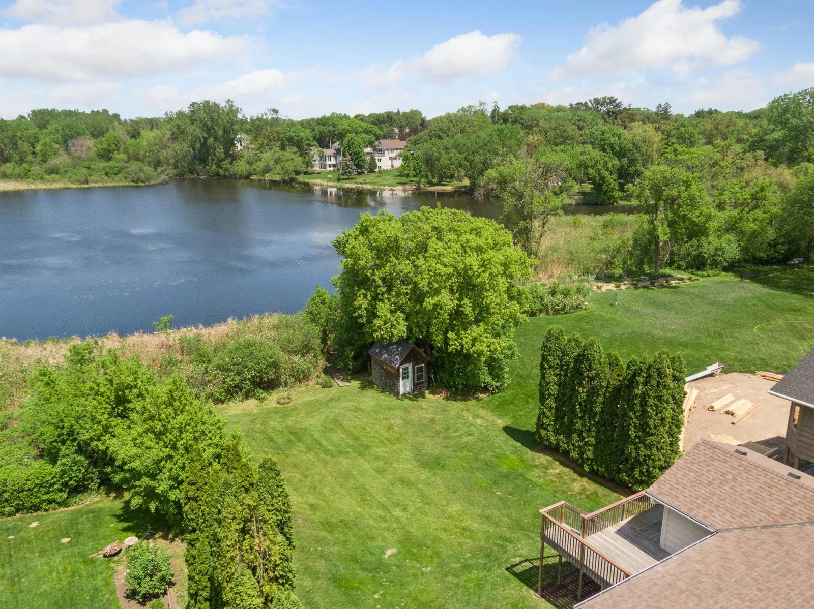 1/3 acre flat lot with arborvitaes flanking each side of the yard