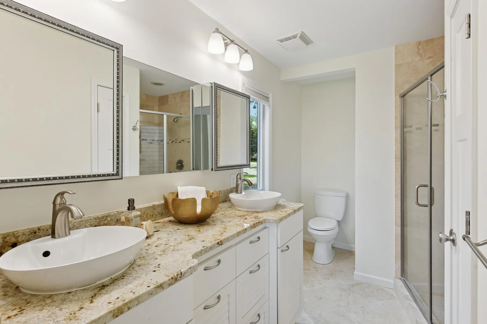 Primary bedroom ensuite with double vanity and tiled shower