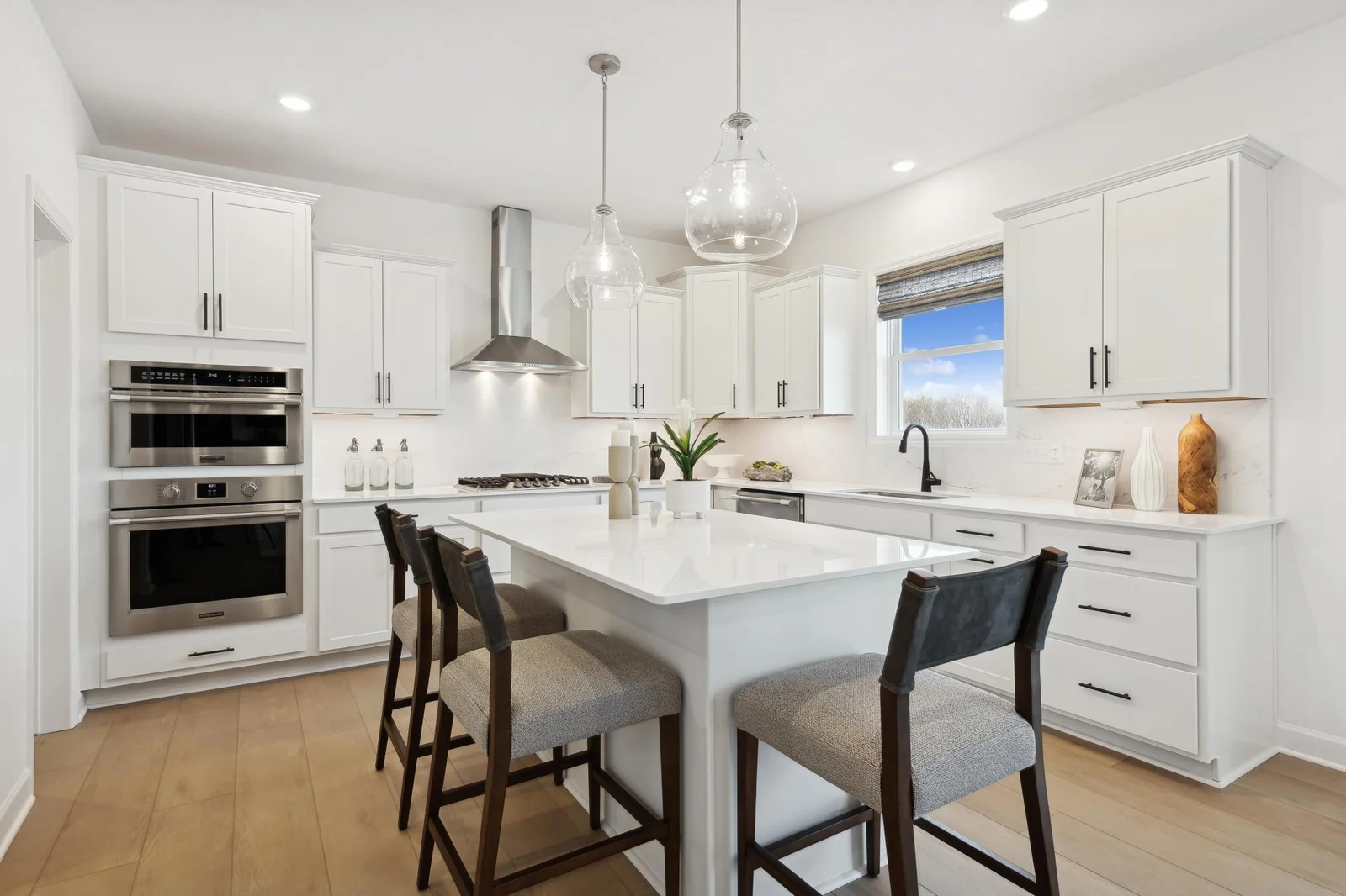 (Photo of decorated model, actual homes finishes will vary) The stunning gourmet kitchen features a large center island, quartz countertops, LVP floors, stainless appliances, and more!