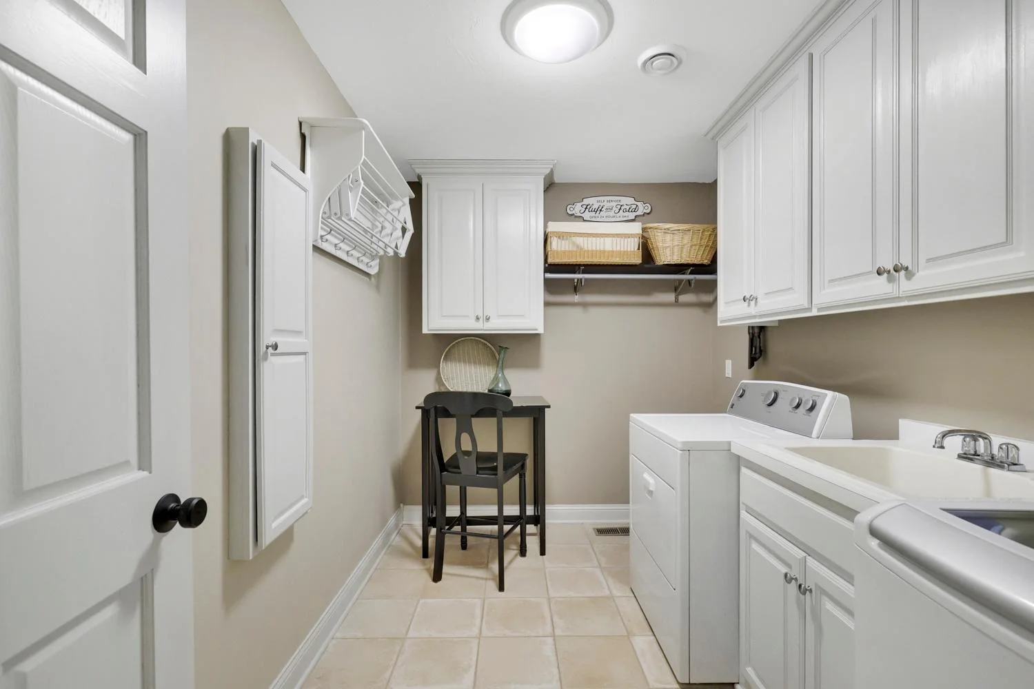 Full laundry room with cabinetry and built in ironing board with room for a work table and crafting area